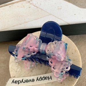 Détail de la pince à cheveux en acétate marine avec nœud en dentelle rose dégradé