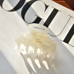 Détail de la pince à cheveux en acétate crème avec texte doré Barrette La France brillant