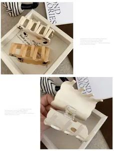 Close-up of matte cat paw claw clips in creamy yellow and light brown with soft texture