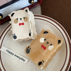 Cute bear-shaped acetate hair claws in cream white and caramel with red bow details