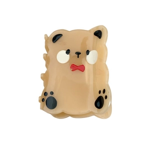 Cute beige bear hair claw clip made of acetate with red bowtie and paw prints detail