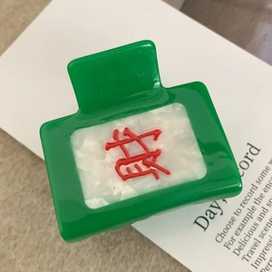Détail de la pince à cheveux Mahjong avec le caractère Fa rouge sur acétate vert