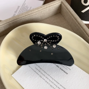Detailansicht einer schwarzen Schmetterlings-Haarklammer aus Acetat mit Glitzersteinen