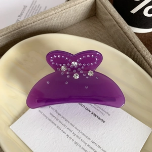Detailansicht einer lila Strass Schmetterling Haarklammer auf einem eleganten Tablett