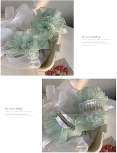 Vue détaillée des pinces à cheveux fleur en organza vert clair avec pince crabe et bec de cygne