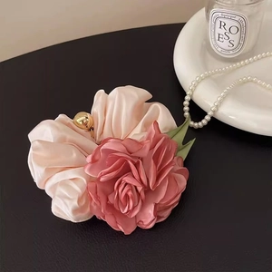 Chouchou fleuri rose élégant avec rose en soie et perle dorée sur fond luxueux