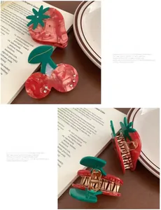 Detail of red marble acrylic strawberry and cherry hair claws with gold metal springs