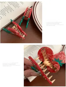 Detail of strawberry hair claw clip with red marble acetate and gold metal teeth