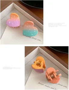 Detail of heart-shaped gradient hair clips with white dot patterns and spring mechanism