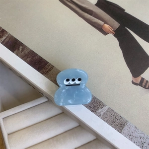 Light blue acetate hair claw clip with cute three-eyed monster design for women