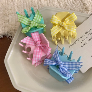 Set of four colorful bow hair claws in macaron pink, mint green, yellow and blue colors