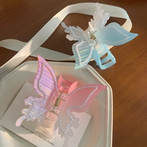 Pinces à cheveux papillon élégantes avec perles et acétate irisé sur table en bois