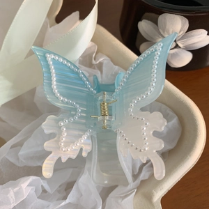 Vue détaillée de la pince à cheveux papillon en acrylique dégradé bleu avec perles