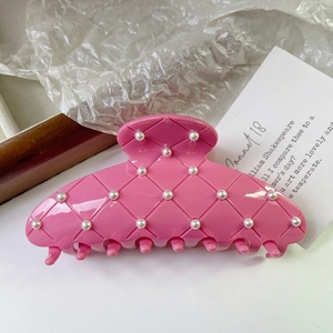 Détail de la pince à cheveux rose matelassée avec perles et texture en résine brillante