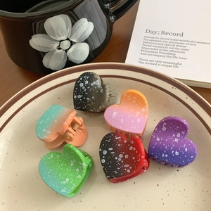 Set of 6 heart-shaped gradient hair claws with white polka dots in a ceramic plate