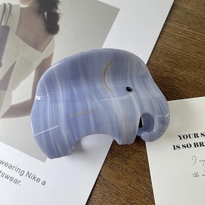 Détail de la pince à cheveux éléphant en acétate bleu clair avec motif marbré élégant