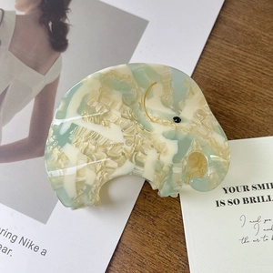 Détail de la pince à cheveux en forme d'éléphant en acétate marbré vert menthe et crème