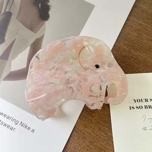 Gros plan détaillé d'une pince à cheveux éléphant en acétate avec texture marbre rose