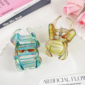 Iridescent plumeria flower hair claws in colorful resin with metallic spring for women