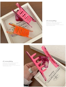 Detail of premium marble pink acetate hair claw clip with silver metal spring design