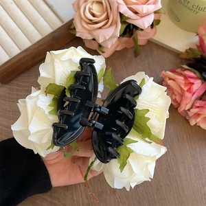 Pince à cheveux élégante avec grandes roses blanches sur base noire, bureau en bois