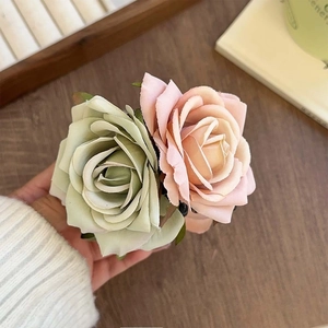 Détail de pinces à cheveux roses en tissu 3D en rose poudré et vert sauge élégant