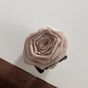 Detailed top view of a large champagne pink fabric rose hair claw clip for women