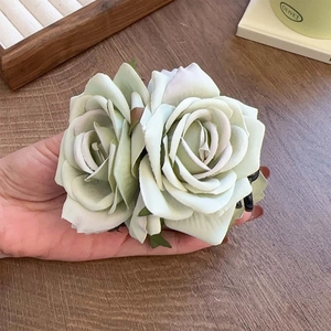 Vue détaillée d'une grande pince à cheveux rose 3D vert clair tenue à la main