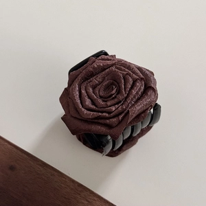 Close-up of elegant dark brown silk fabric rose flower hair claw clip with vintage style