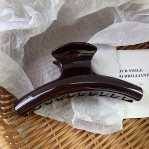Detail view of large dark brown PC shark hair claw clip with a glossy finish for hair styling