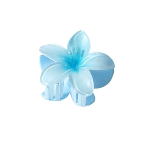Pince à cheveux fleur de frangipanier bleu clair nacré avec dégradé mat sur fond blanc