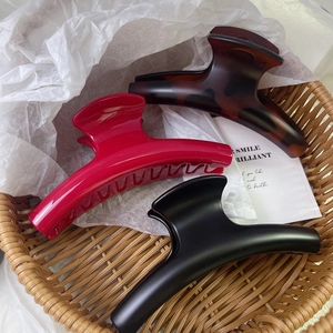 Three elegant French style large hair claws in matte black, burgundy, and tortoise shell
