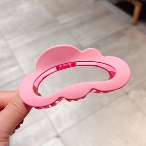 Close-up of a large pink matte cloud-shaped hair claw clip with a secure spring mechanism