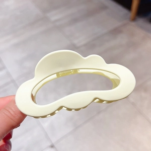Detail of matte cream-colored cloud hair claw clip for thick hair styling