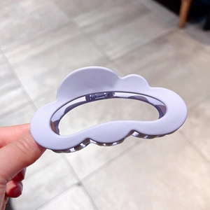 Close-up of matte lavender cloud hair claw clip for thick hair held in hand