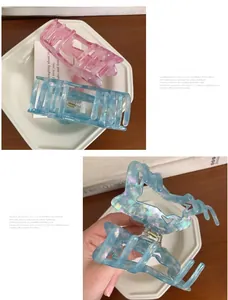 Close-up of large acetate hair claws in laser blue and pink with pearl texture