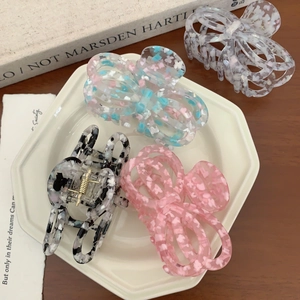 Set of four floral acetate butterfly hair claws in pink, blue, black, and lavender