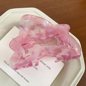 Detailed close-up of pink marble pattern acetate hair claw clip with geometric hollow design