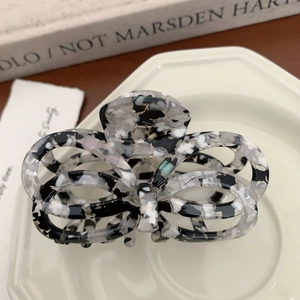 Macro detail of French acetate butterfly hair claw clip with black and white marble pattern