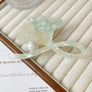 Detail showing the marbled ginkgo leaf hair claw clip with a white pearl accent