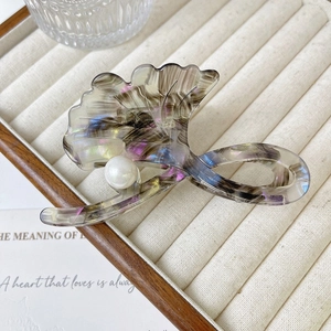 Detail of ginkgo leaf hair claw with colorful marble texture and a large pearl accent