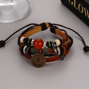 Detail of multi-layer leather bracelet featuring Gemini sign and red agate bead