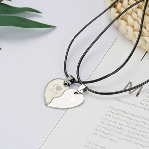 Detail of interlocking heart pendants for couples with love engraving on black cord