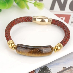 Bracelet tressé en cuir avec œil de tigre et fermoir magnétique doré sur fond blanc