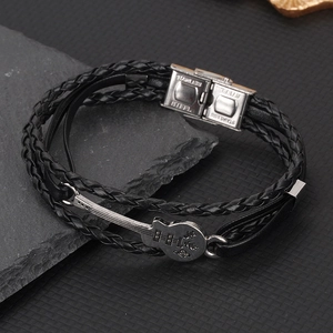 Dettaglio del bracciale in pelle multistrato con ciondolo chitarra e chiusura in acciaio