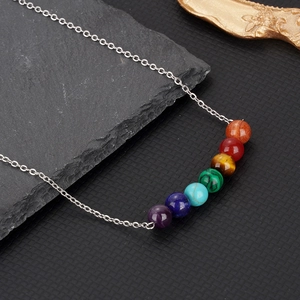 Détail de sept perles en pierre naturelle chakra sur une chaîne en acier poli argenté