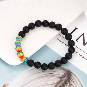 Rainbow beaded friendship bracelet with matte black beads on a white tray