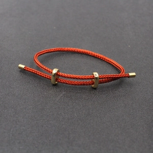 Détail du bracelet en corde d'acier tressée rouge avec fermoirs coulissants dorés polis