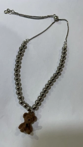 Detail of beaded fashion necklace with cute plush bear pendant and adjustable sliding clasp