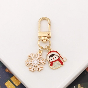 Christmas keychain with a cute enamel penguin and snowflake pendant on gold metal ring